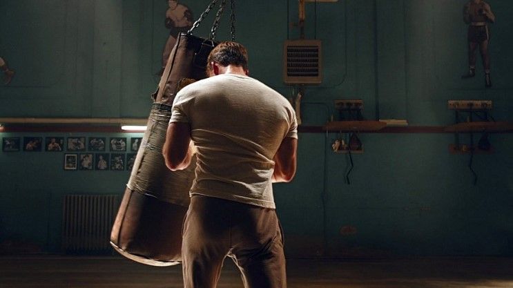 Steve Rogers punching a heavy bag in a dark gym